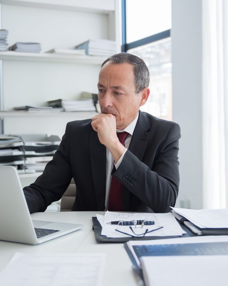 A senior finance professional reviewing a client’s numbers at his desk
